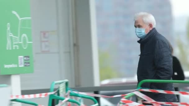 Старий у масках ходить на базарі за їжею. Люди захищають коронавірус covid-19 — стокове відео
