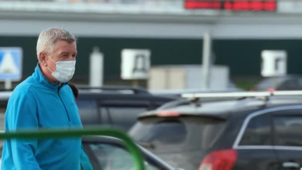 Maskovaný stařec chodící na trh pro jídlo. Lidé chránili koronový virus covid-19. — Stock video