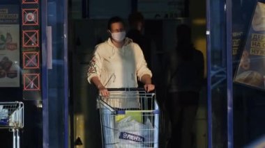 İnsan maskesi araba koronası virüsünden malzeme alır. Alışveriş merkezi tüketicisi covid-19.