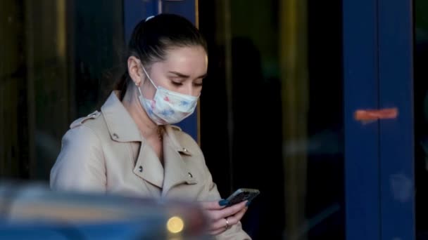 Woman in masks wait with phone hand coronavirus. Girl stand with mobile covid-19 — Stock Video