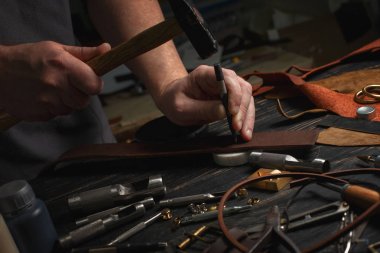 DIY araçları işçiliği kullanarak deri ile çalışan adam