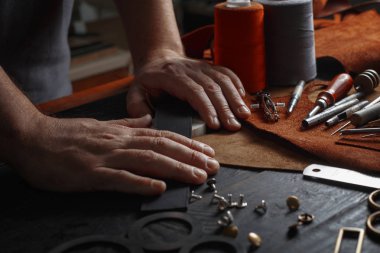 DIY araçları işçiliği kullanarak deri ile çalışan adam