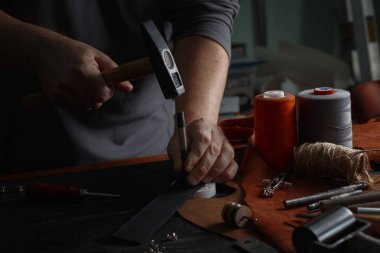 DIY araçları işçiliği kullanarak deri ile çalışan adam