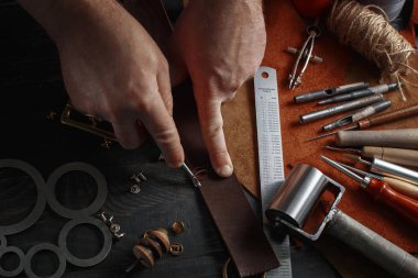 DIY araçları işçiliği kullanarak deri ile çalışan adam