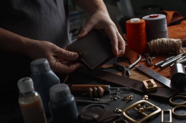Man working with leather using crafting DIY tools clipart