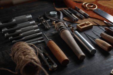 Ahşap arka plan üzerinde deri el sanatları araçlar kümesi. İş yeri için kunduracı. Bir iş tabl gizle ve çalışma el yapımı araçları parçası