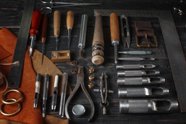 Ahşap arka plan üzerinde deri el sanatları araçlar kümesi. İş yeri için kunduracı. Bir iş tabl gizle ve çalışma el yapımı araçları parçası