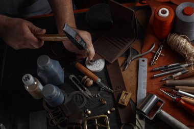 Man working with leather using crafting DIY tools clipart