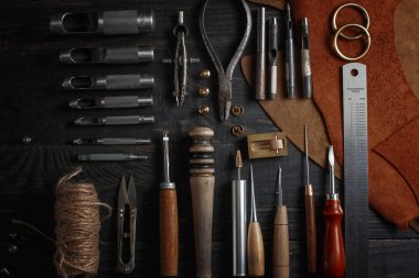 Ahşap arka plan üzerinde deri el sanatları araçlar kümesi. İş yeri için kunduracı. Bir iş tabl gizle ve çalışma el yapımı araçları parçası
