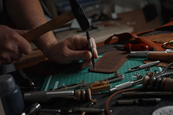 Man working with leather using crafting DIY tools