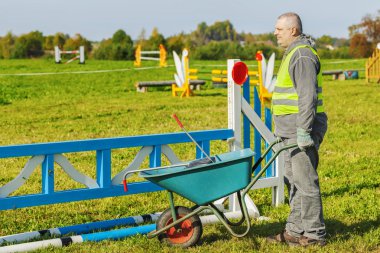 At işleyicisi engel sahada el arabası ile 