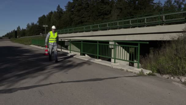 Trabalhador da construção rodoviária mostrar parar gesto e colocar cone de tráfego — Vídeo de Stock