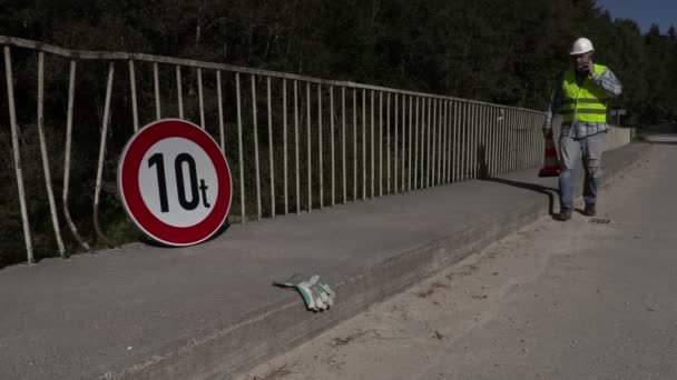 Road construction worker talking on phone and walking — Αρχείο Βίντεο