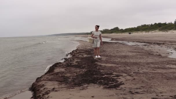 Frau mit Korb geht am Ufer des Meeres entlang — Stockvideo