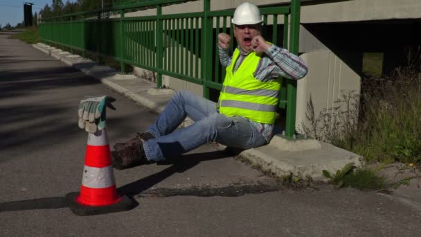 Trabajador de la construcción de carreteras bosteza en el puente — Vídeo de stock