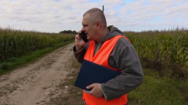 Corn Field'da akıllı telefonda konuşurken çiftçi
