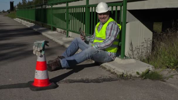 Road construction worker using tablet PC and laughing — Stock Video