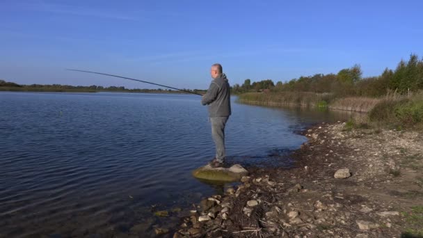 Hombre con spinning en el lago — Vídeo de stock