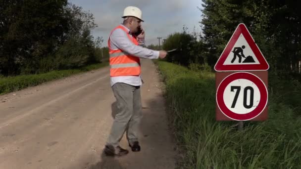 Ingénieur près des panneaux routiers de la réparation de la route — Video