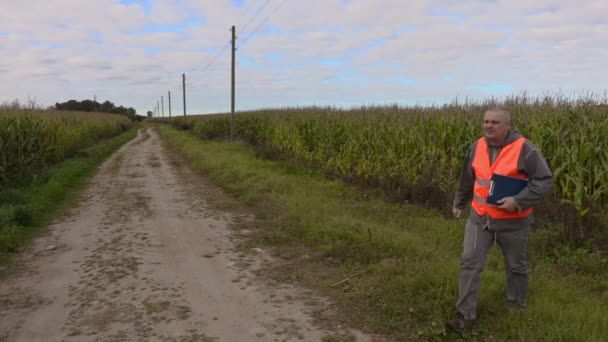 Boer komt uit op de weg van het maïsveld — Stockvideo