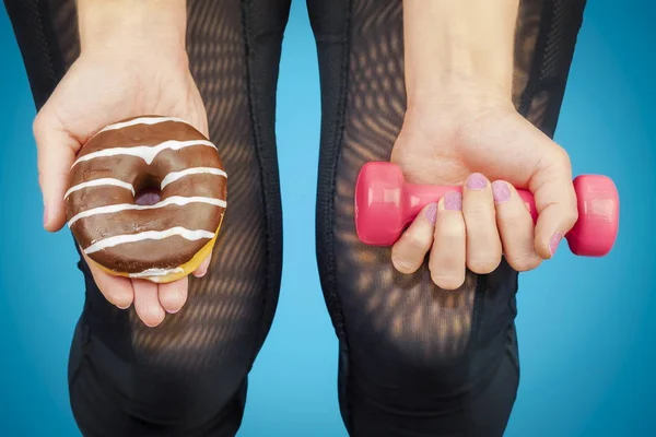 Mujer con mancuerna y rosquilla en las manos de — Foto de Stock