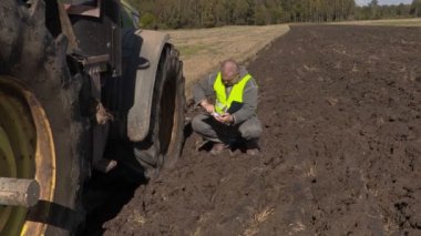 Traktör alanında yakınındaki belgeler ile çiftçi