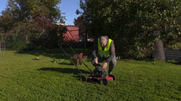 Arbetstagaren börjar gräsklippare — Stockvideo