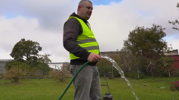 Landskapsarkitektur arbetare prata telefon och vattna gräsmattan — Stockvideo