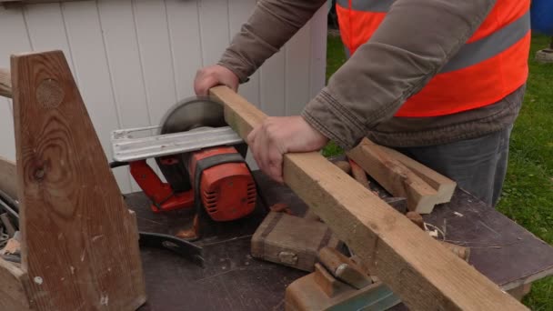 Плотник пилит деревянную доску циркулярной пилой — стоковое видео
