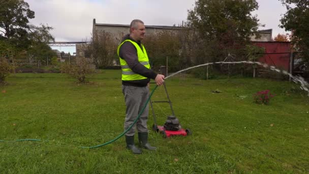 Ландшафтный рабочий поливает газон — стоковое видео