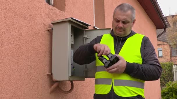 Электрик проверяет предохранители рядом с домом — стоковое видео