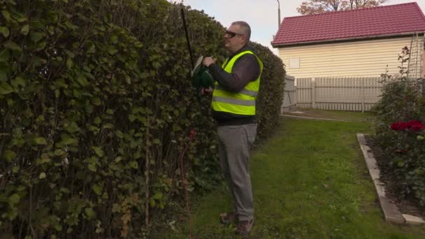 Landskapsarkitektur arbetare kontrollera bush hedge — Stockvideo