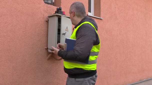 Electricista usando tableta cerca de caja de fusibles — Vídeos de Stock