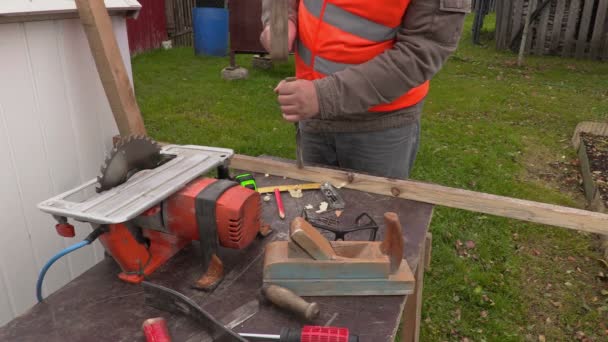 Плотник с помощью молотка и зубила за рабочим столом — стоковое видео