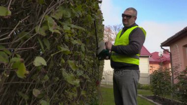 Peyzaj işçi fırça kesici kullanır 