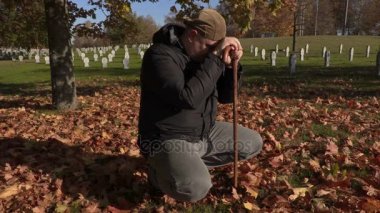 Sonbahar mezarlığı koltuk değneği ile depresif adam