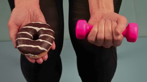 Mulher tentando fazer escolha entre donut e exercício — Vídeo de Stock