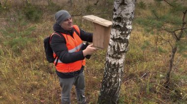 Kuşbilimci huş ormandaki yakınındaki kuş yuva kutusuyla