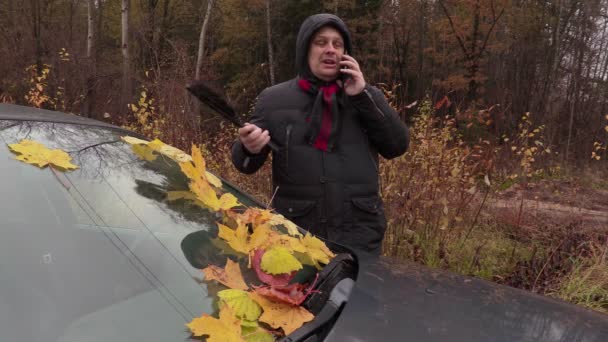 Mann telefoniert und putzt Autoscheibe — Stockvideo