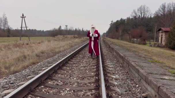 Санта-Клаус ходит по железной дороге — стоковое видео