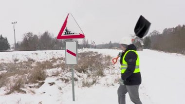 Uyarı işareti kar road yakınındaki temizlik işçisi
