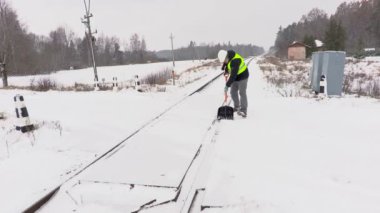 Demiryolu çalışanı temiz kar üzerinde demiryolu geçişi