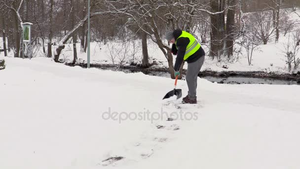 Уборщик очищает тротуар от снега — стоковое видео