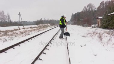 Demiryolu çalışanı temiz kar yakınındaki demiryolu platformu