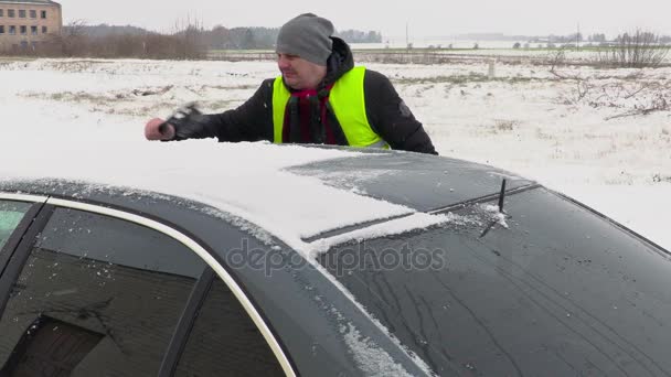 Mann reinigt Auto vom Schnee — Stockvideo