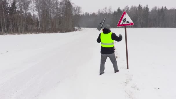 Man clean road sign from the snow — Stock Video