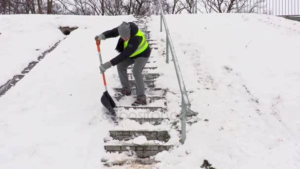 Vaktmästare med snöskyffel kliva ner och rengöring trappor — Stockvideo