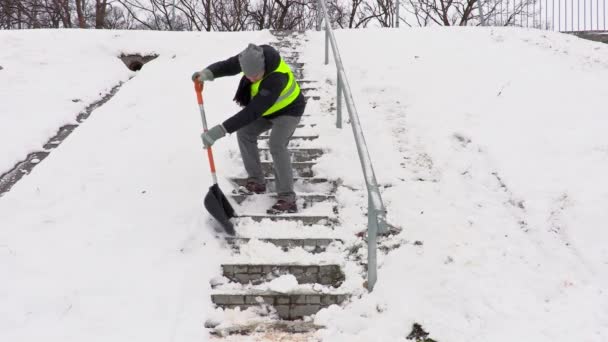 Školník s lopata na sníh sestoupil a čištění schodů