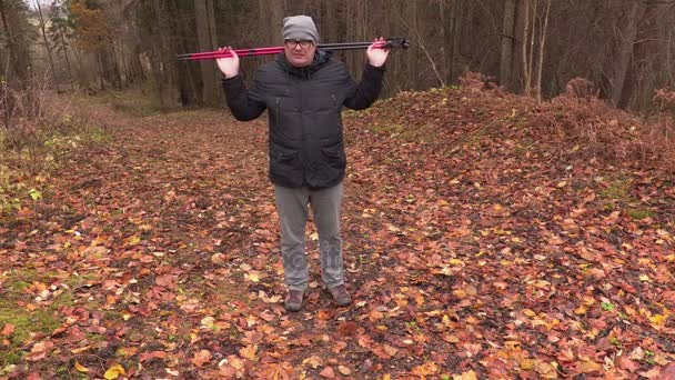 Escursionista con bastoncini riscaldati nel parco — Video Stock