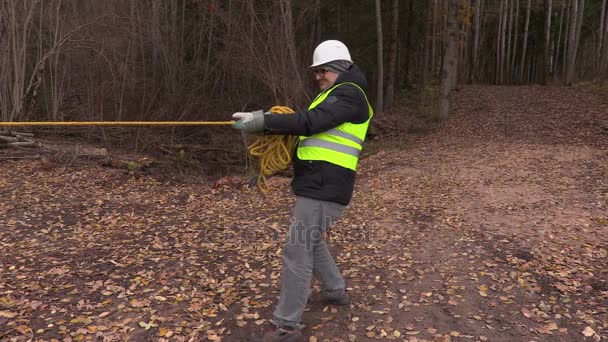 Trabajador tirando de la cuerda en el bosque — Vídeo de stock